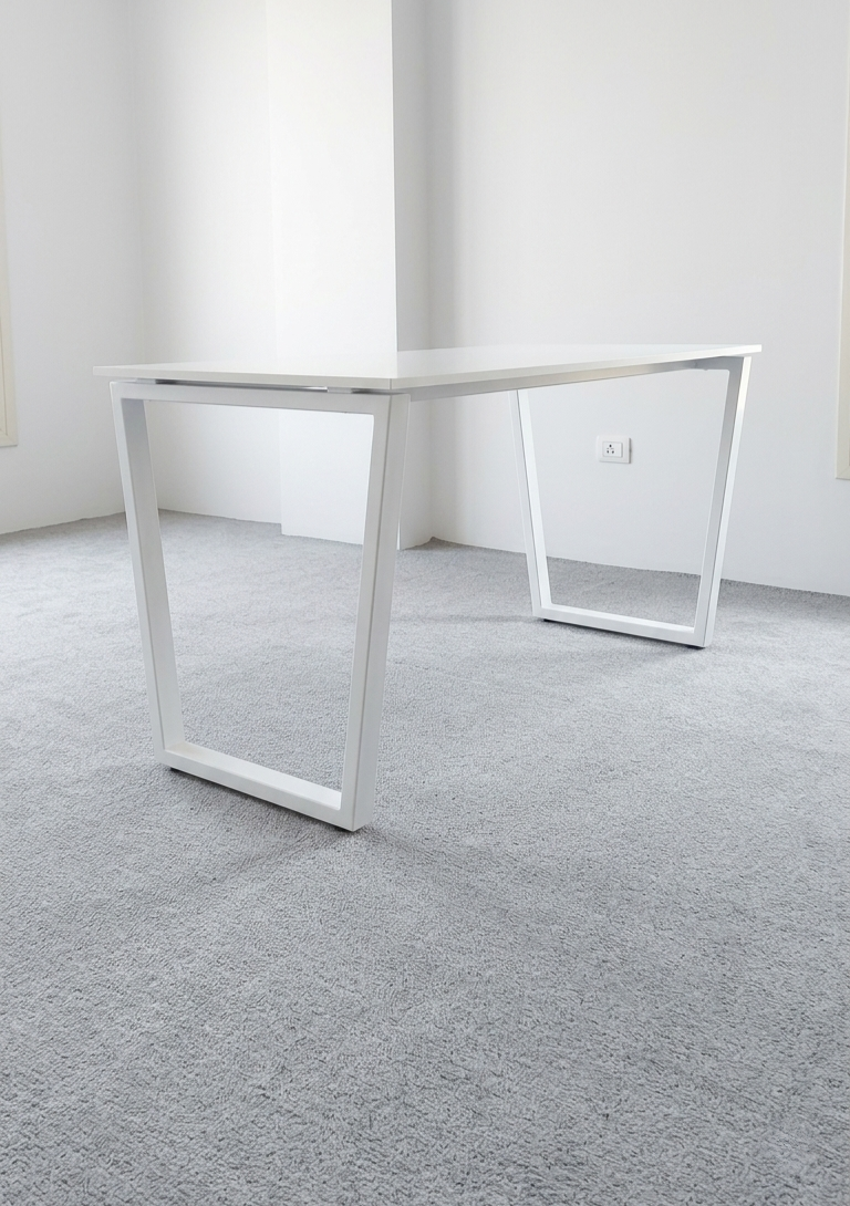 White office desk in a minimalistic room with gray carpet and white walls.